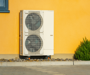 Outdoor heat pump on a yellow commercial building serviced by Parkers Heating & Cooling Tennessee.