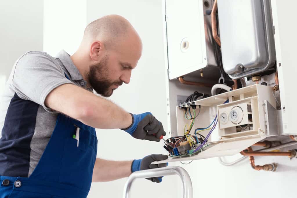 HVAC service tech doing maintenance on a heating system